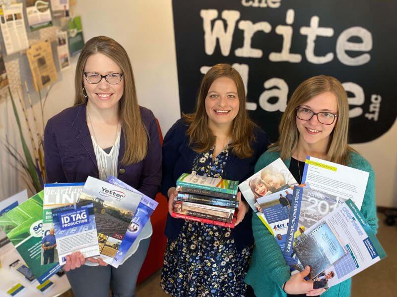 Michelle Stam, Sarah Purdy, and Sarah Naberhaus holding books, flyers, and brochures