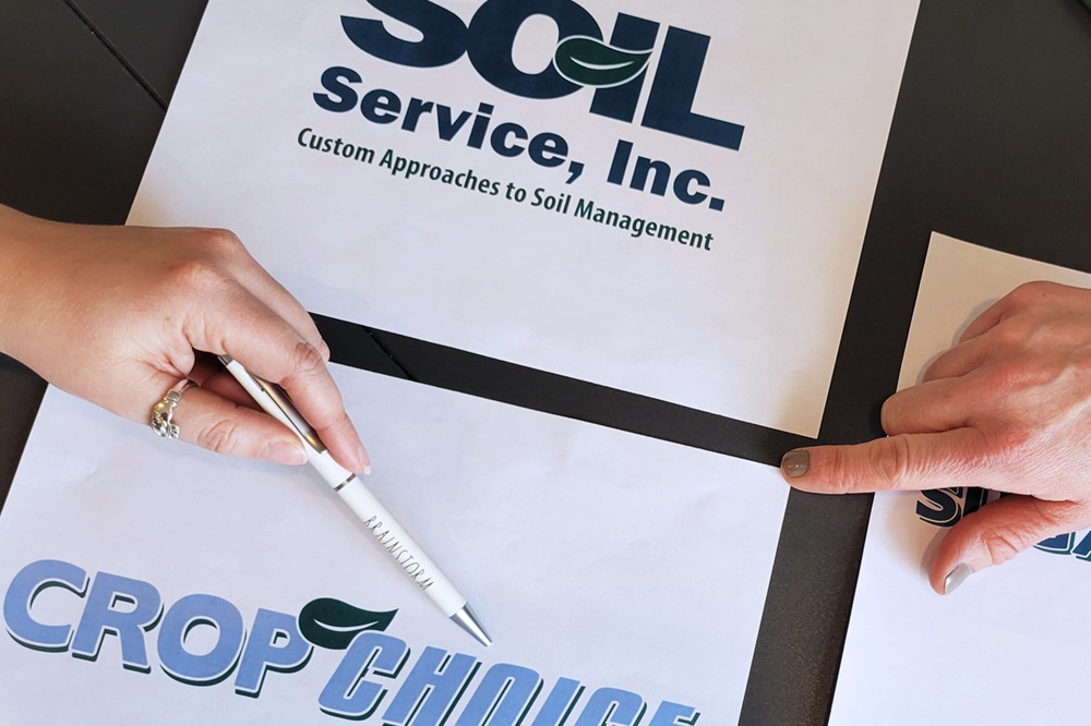 Closeup of hands pointing to printed business logos